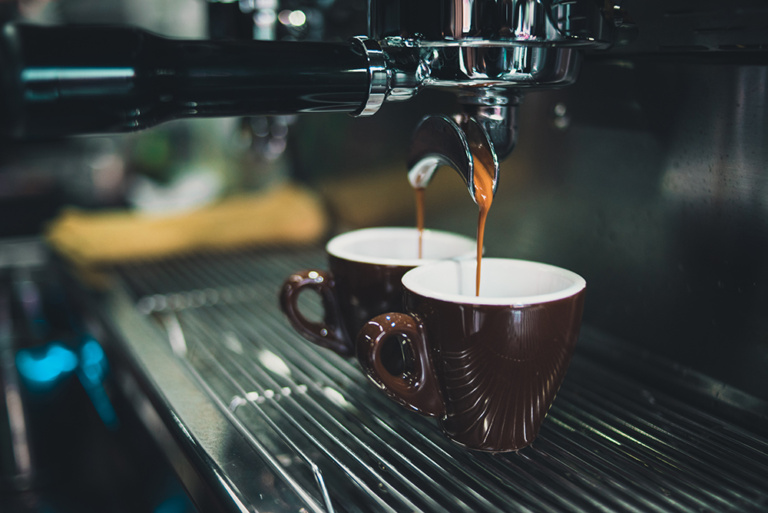 Kavos apratas, bėganti kava į kavos puodelį